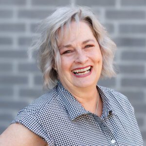 Tana wearing a black and white top and smiling at the camera
