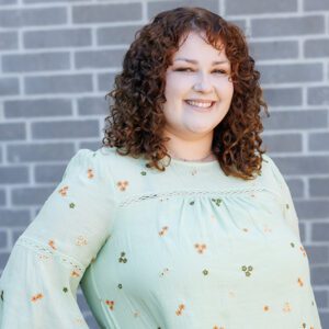 Kylie Price wearing a long sleeve shirt and smiling at the camera