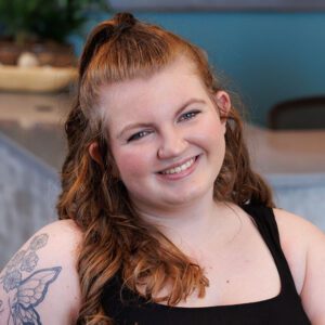 Madison wearing a black top and smiling at the camera