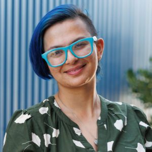 Angela wearing a green and white top and smiling at the camera