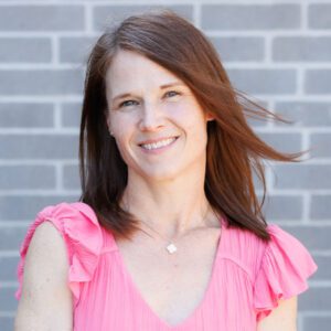Erin wearing a pink top and smiling at the camera