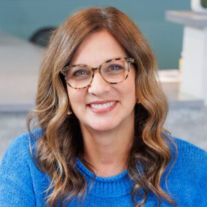 Michelle Casey wearing a blue sweater and smiling at the camera